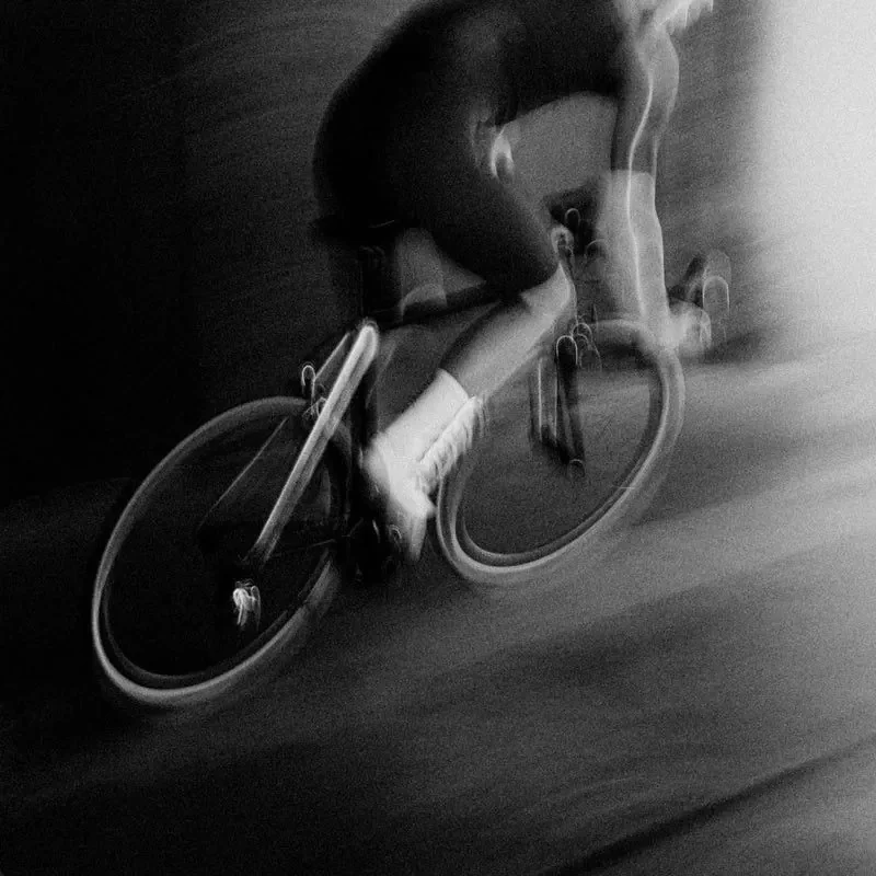 Cyclist moving through the city in a black-and-white long-exposure photograph
